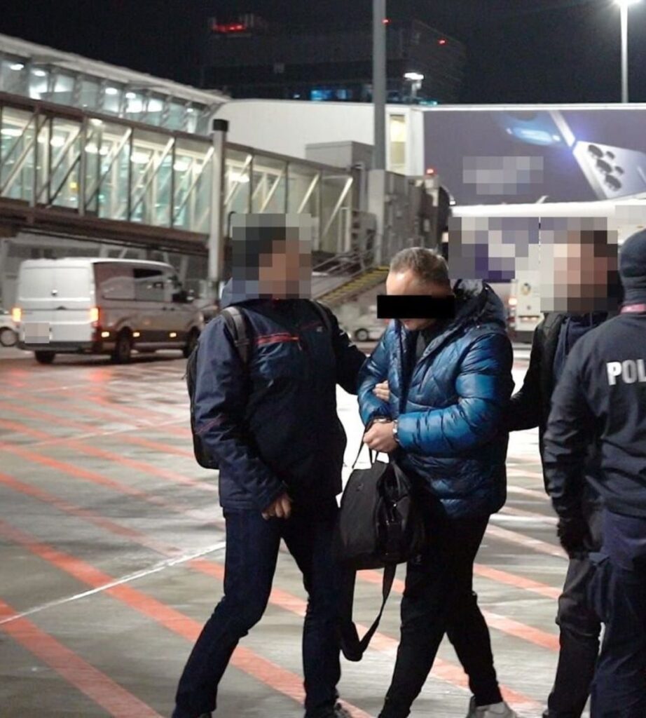 42-letni Polak odnaleziony przez „łowców głów” Foto: aresztowany mężczyzna eskortowany przez policjantów na lotnisku