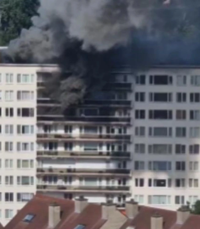 Gęsty dym unoszący się nad płonącym blokiem mieszkalnym